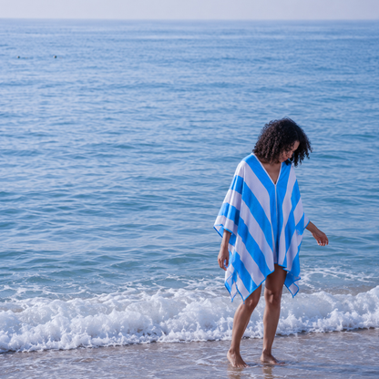 Woman walking out of the sea wearing the lightweight micro-fibre Zippa towel, hands free
